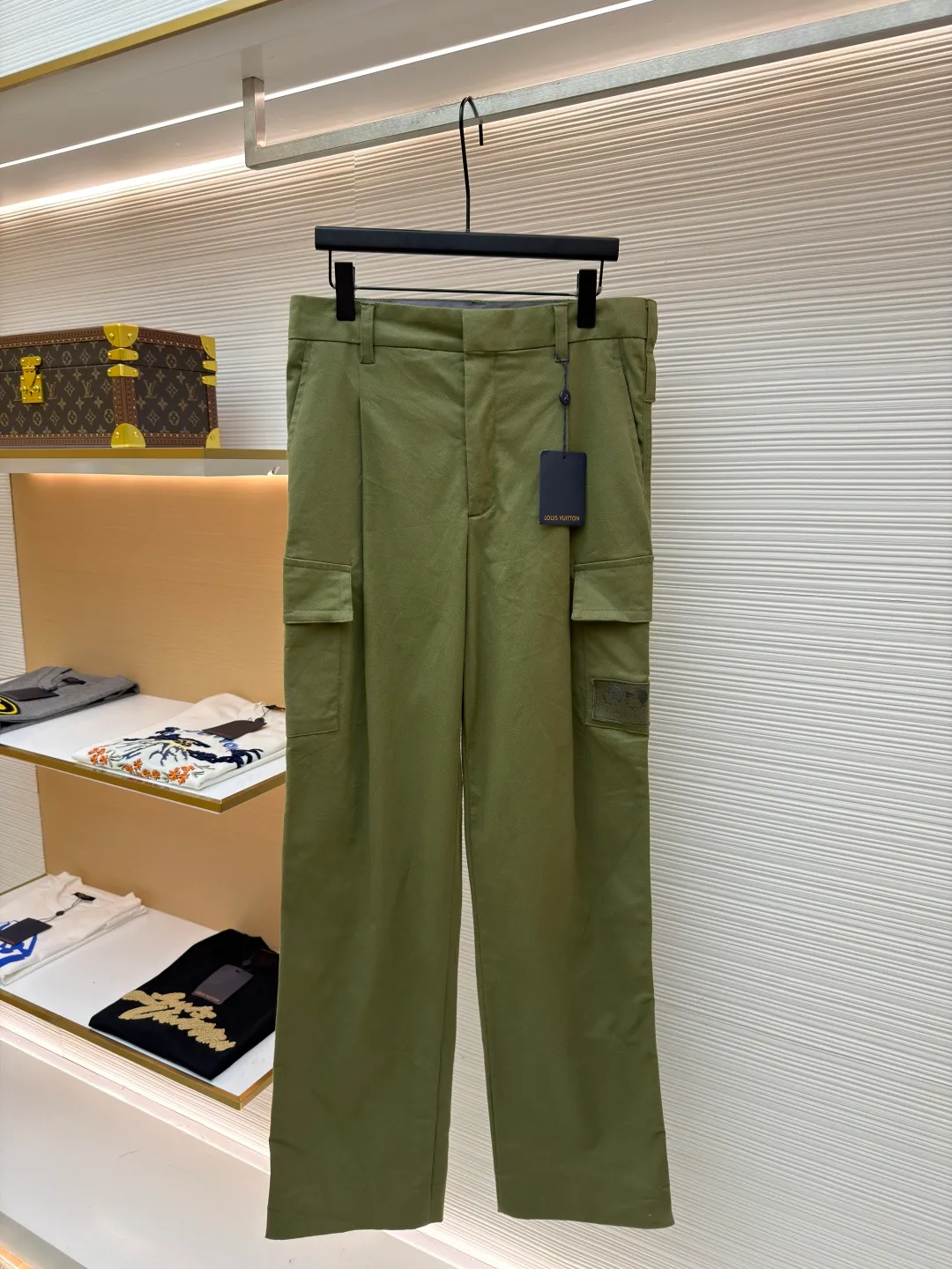 LOUIS VUITTON portrait embroidered work trousers ●Item number: 1681219-B65 ●Material: cotton twill fabric ●Technology: embroidery production ●Color: green ●Version: fitted version ●Weight: about 655 grams ●Size: 44-46-48-50 ●Description: The high cotton content ensures the fabric's excellent breathability, durability and classic workwear texture, while the twill weave gives it unique wear resistance and stiffness. The special fabric technology solves the pain points of tight and stiff traditional overalls; it provides greater freedom when moving, significantly improves wearing comfort and flexibility, and achieves a balance between function and comfort. For the embroidered portrait patch on the left, the portrait is digitally processed and converted into a line drawing blueprint that can be embroidered. A high-precision computer embroidery machine is used to perform multi-layer embroidery, and the outline, light and shade and texture details of the portrait are created by interweaving and superimposing embroidery threads of different colors. Tens of thousands of stitches and fine color transitions ensure clear lines and no unnecessary threads, making the portrait lifelike and three-dimensional. The design of the trousers combines retro workwear genes with modern deconstruction. The core lies in the neat pleat processing, which not only deconstructs the flat silhouette of the front, increases the three-dimensional sense and design level, but also visually optimizes the leg lines. Multiple flap pockets are classic workwear functional elements and the overall tough style. The overall wiring is straight and delicate, the fabric is comfortable and soft, and the color is consistent without color difference. It can be matched with the same style to create a fashionable look and control various occasions. Customized accessories, complete with three standards, same style for men and women!
